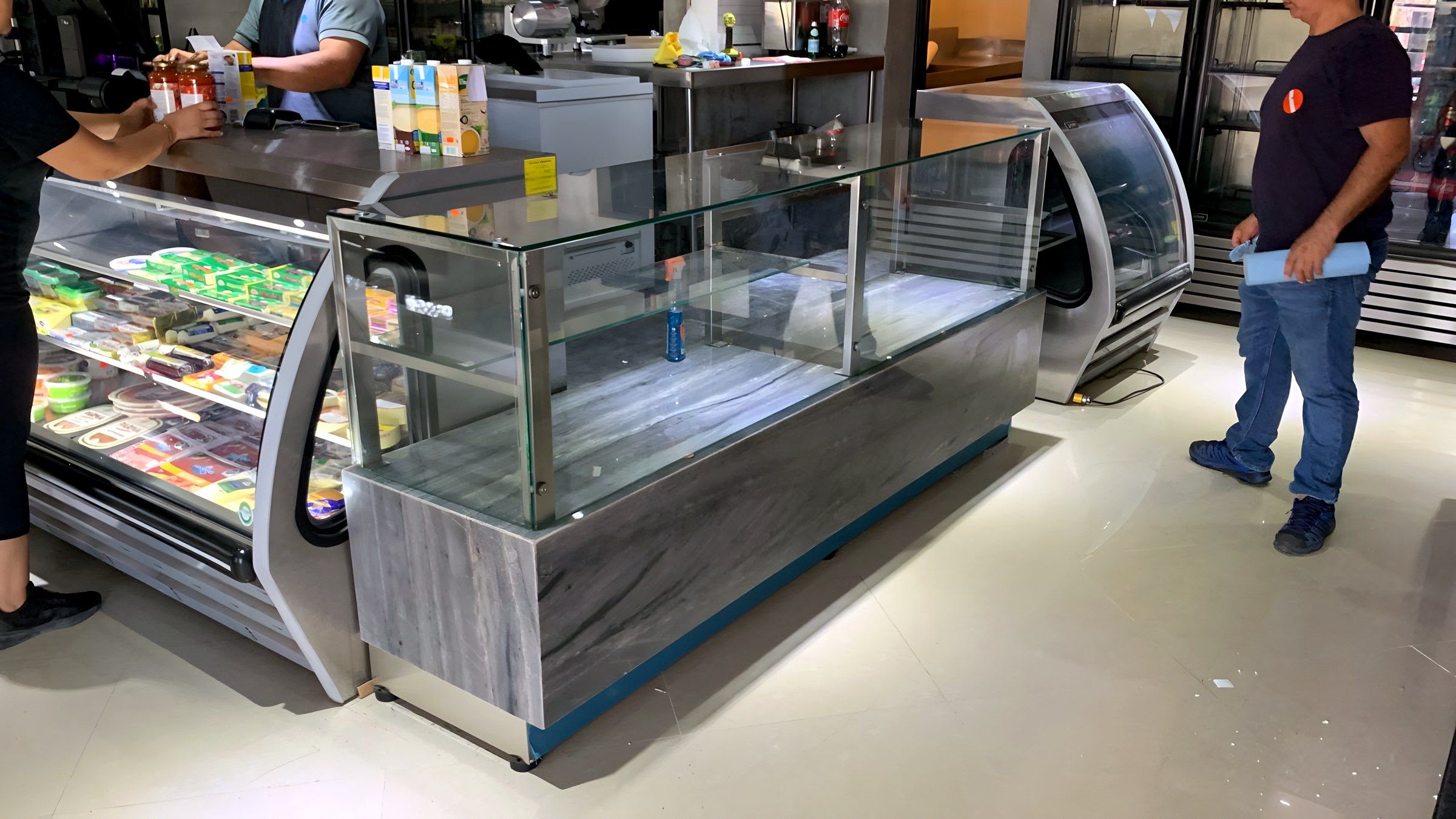 Vitrinas refrigeradas y mostrador de cristal en un área de venta.