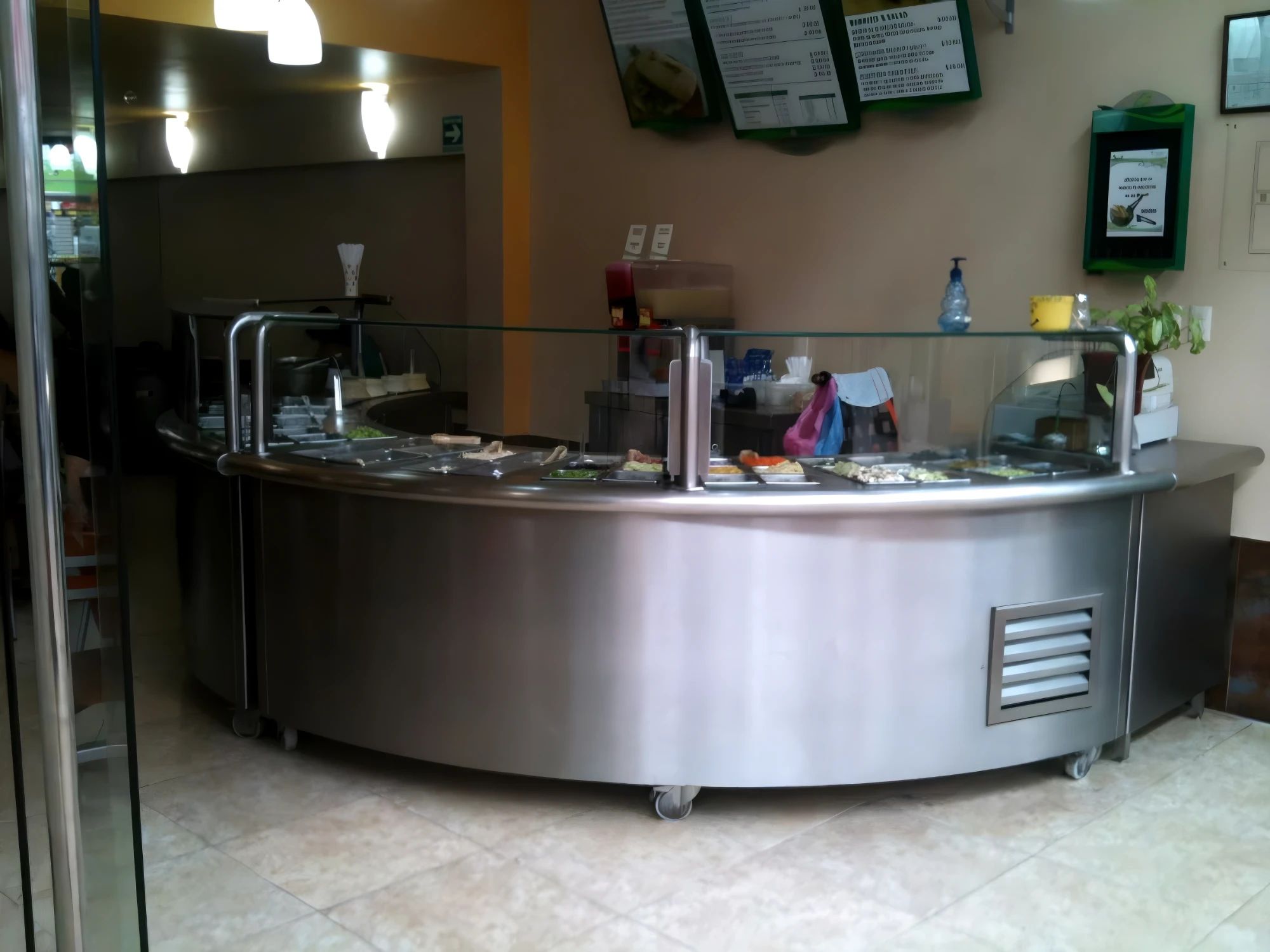 Barra de buffet curva en acero inoxidable con protector de cristal.